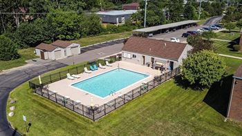 A pool surrounded by a fence with a building in the background.